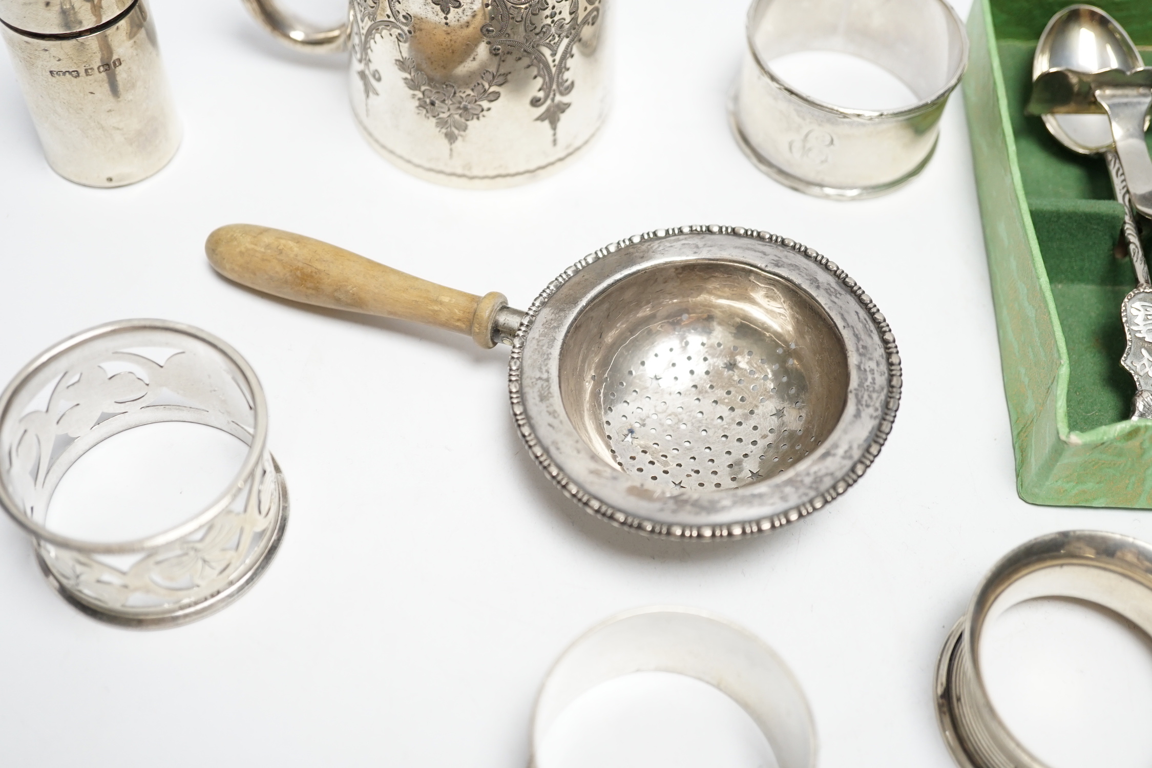 A Victorian engraved silver christening mug, Charles Stuart Harris, London, 1887, 71mm and other items including silver scent bottle, napkin rings and tea strainer.